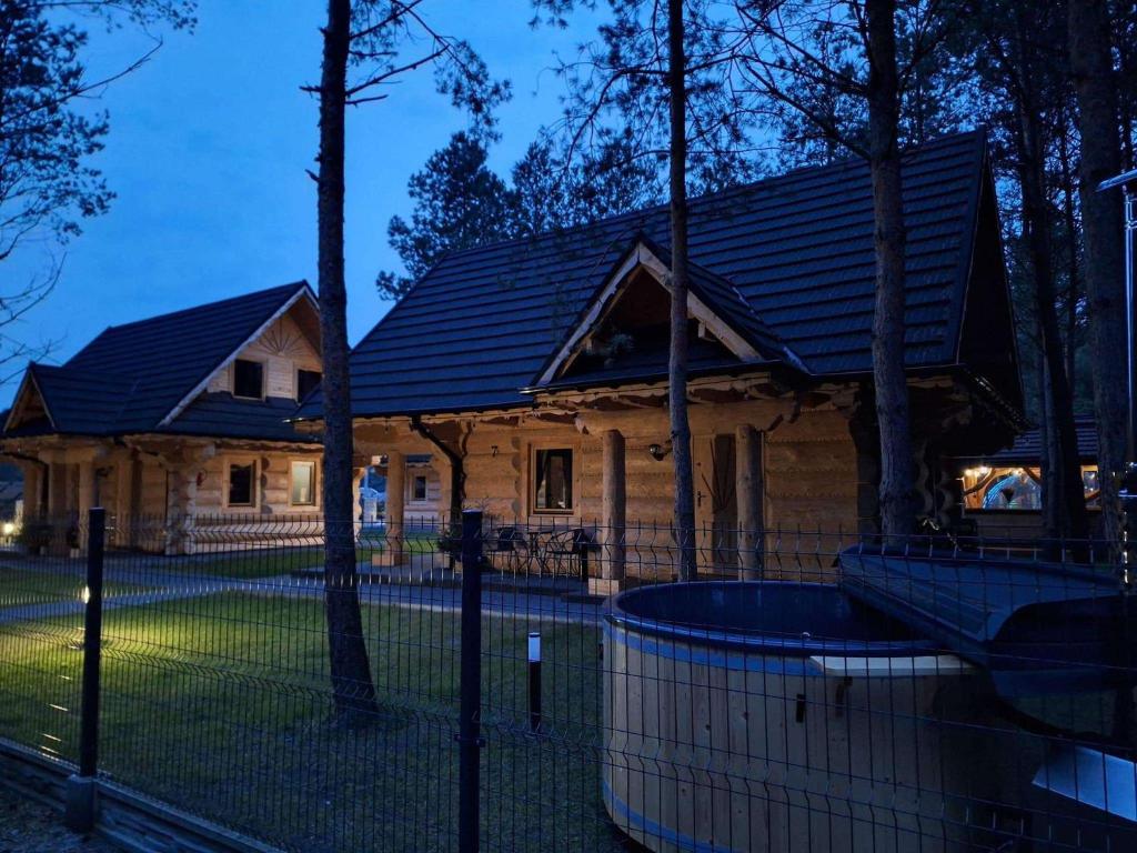 a house with a fence in front of it at Ośrodek u Polaka-domek góralski in Radkowice