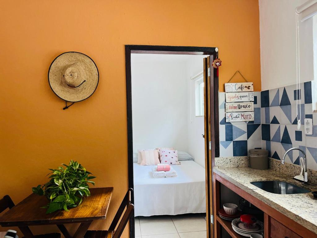 a bathroom with a sink and a room with a bed at Microcasa Aconchego Paraty in Paraty