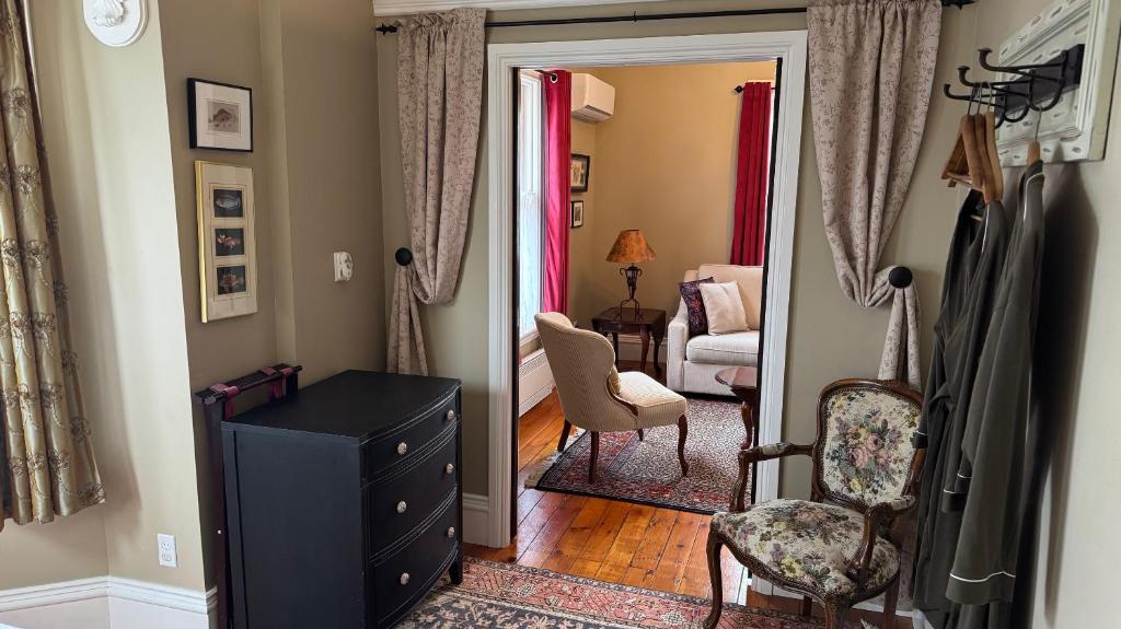 a living room with a black dresser and a chair at The 1885 Suites in Picton