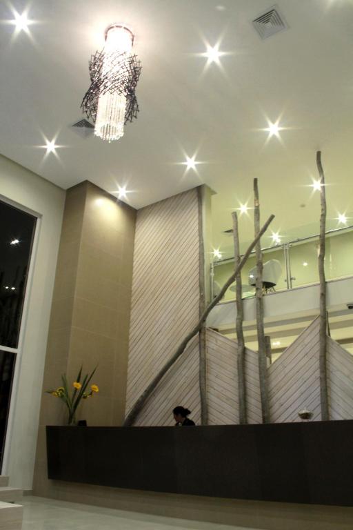 a person sitting in a lobby with a chandelier at Ecohotel Talca in Talca