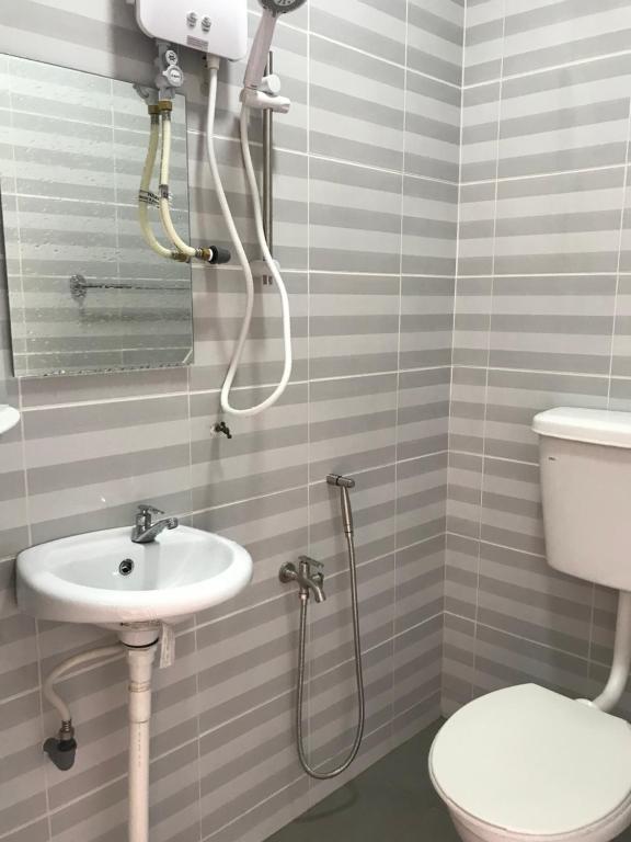 a bathroom with a toilet and a sink at Ilham Bonda Homestay II LELAKI SAHAJA in Kampong Jaya