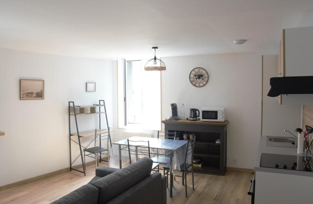 un salon avec un canapé et une table dans l'établissement Au coin de la rue, à Vatan