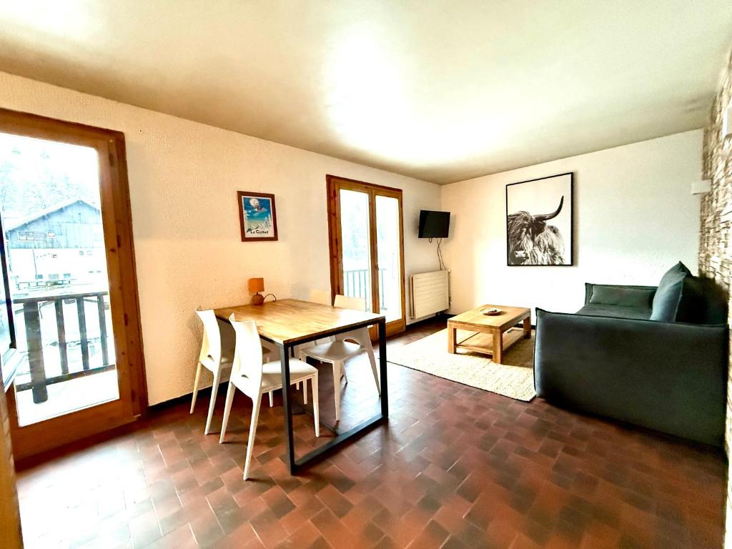 a living room with a table and a couch at La clusaz Centre village , pied des pistes, 42 m2 , balcon sud vue montagne in La Clusaz