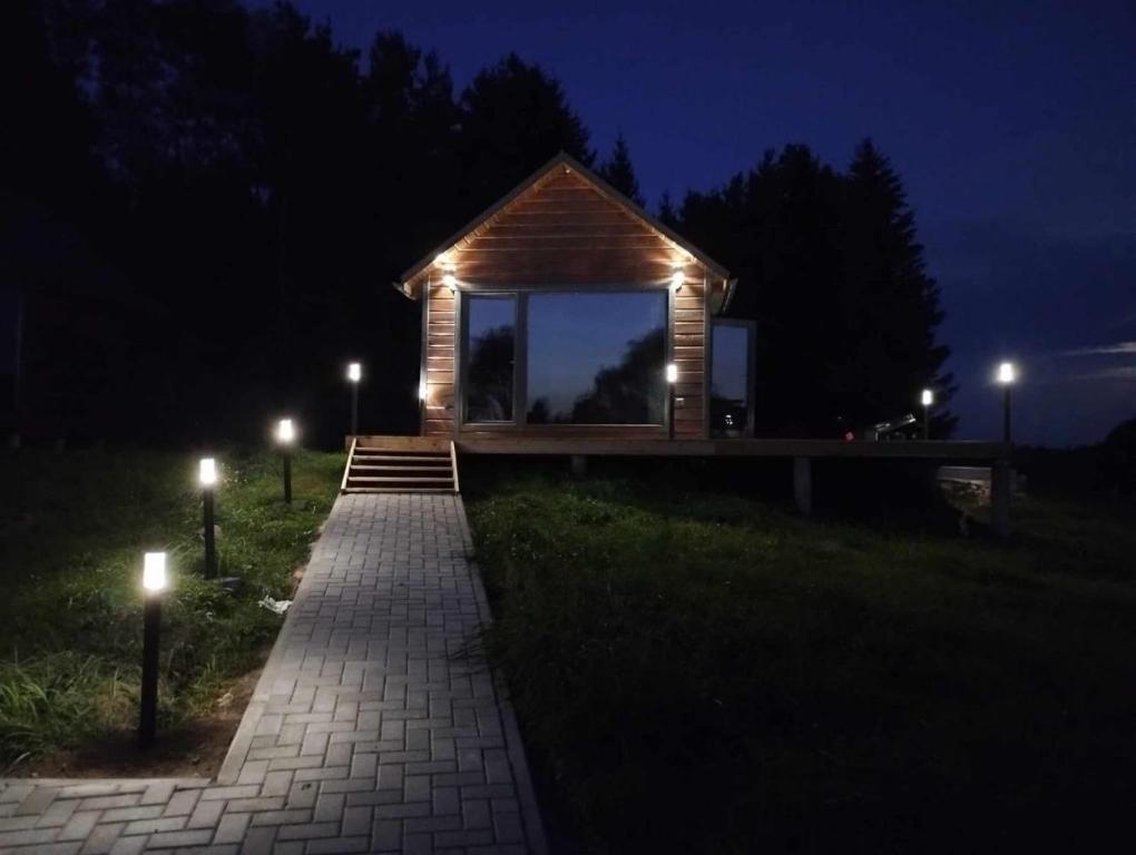 ein kleines Gebäude mit Lichtern in der Nacht in der Unterkunft TORA nameliai in Aukštadvaris