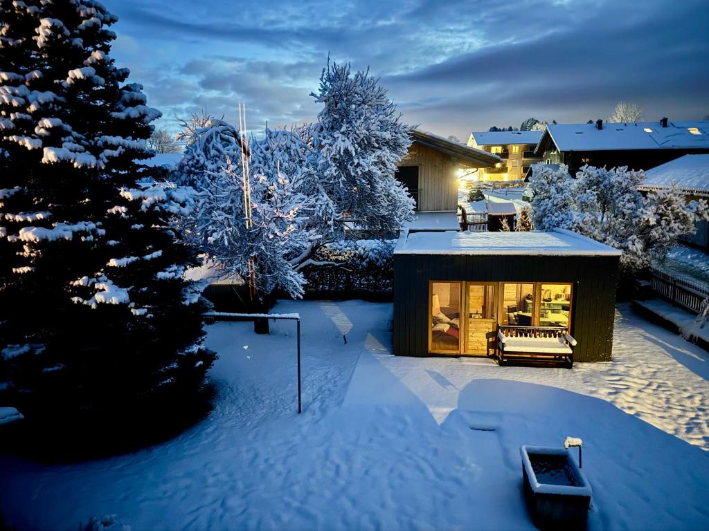 a house covered in snow in a yard at Casa Natur Pur, 85m2 mit Garten Sauna in Fischbachau