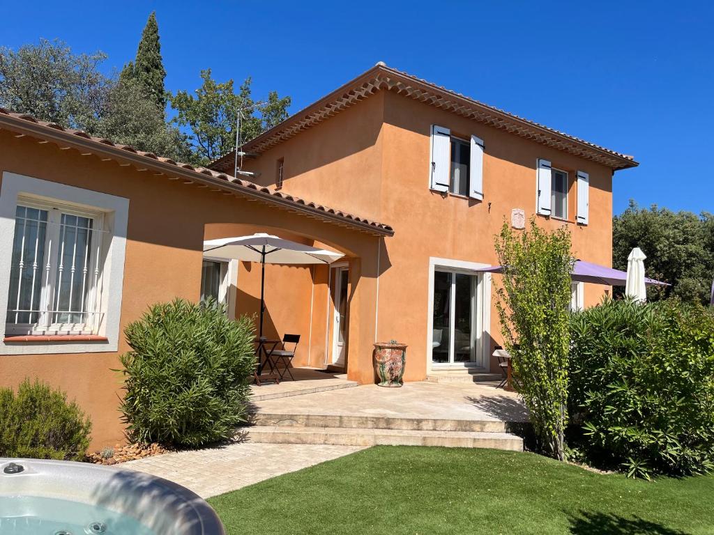 une maison avec un parapluie devant dans l'établissement Charmante villa avec spa et panorama, à Lorgues