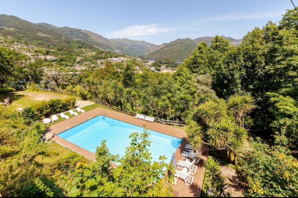 einen Blick über einen Pool mit Bergen im Hintergrund in der Unterkunft Casa Soutinho - Gerês in Ventosa