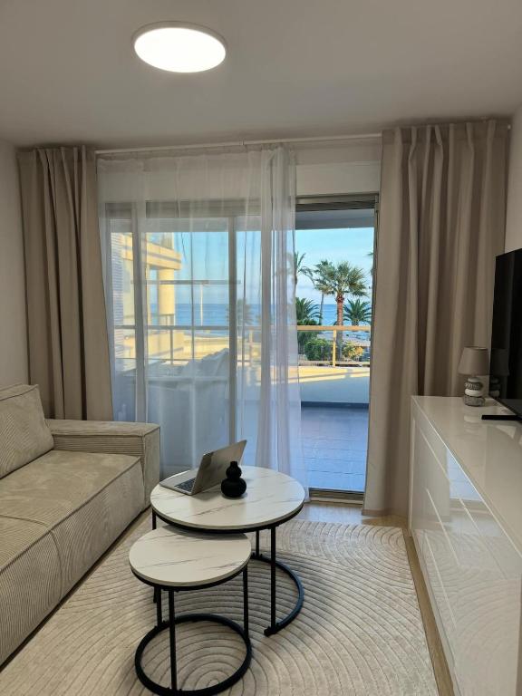 a living room with a couch and a table with a laptop at Apartament Premium Hipocampos in Ifach