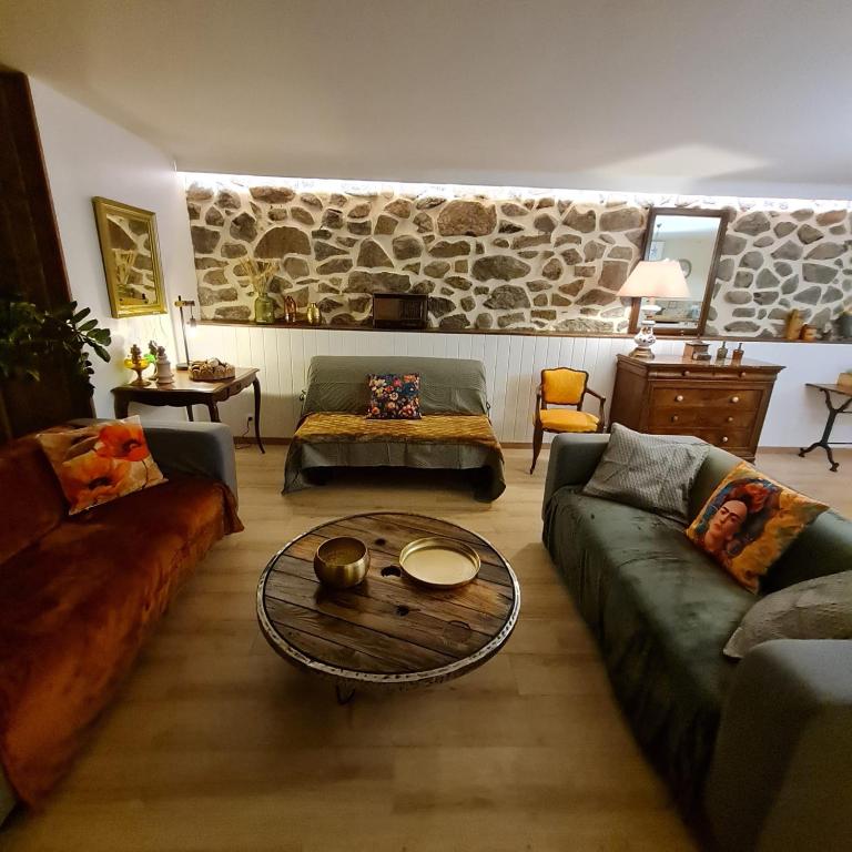 un salon avec des canapés et une table basse dans l'établissement Appartement Puy Mary By les Monts du Cantal, à Murat