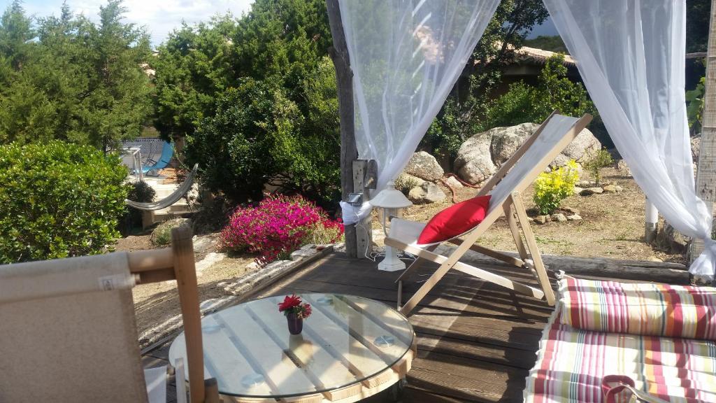 - une table et des chaises sur une terrasse couverte avec une table dans l'établissement Villa bord de mer, à Sartène