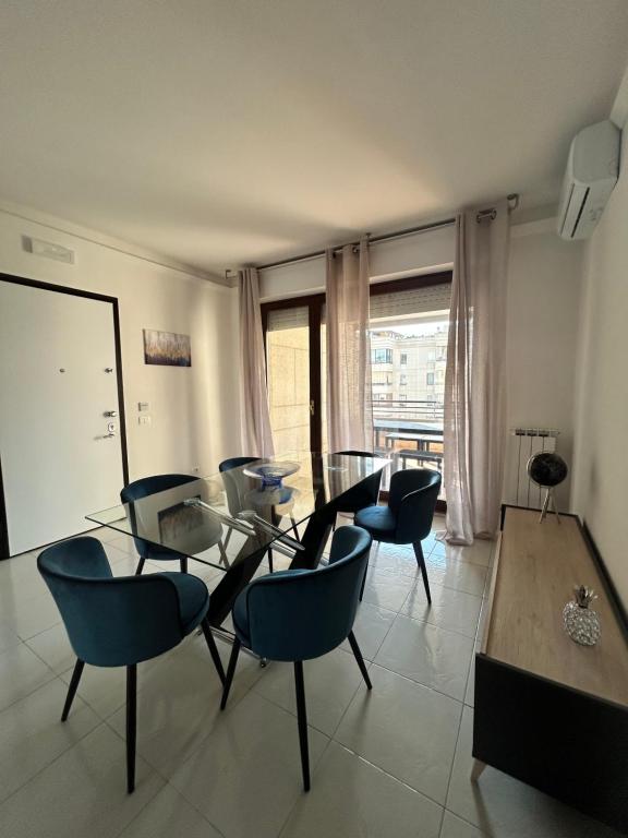 a dining room with a glass table and chairs at Appartamento Astri EUR in Rome