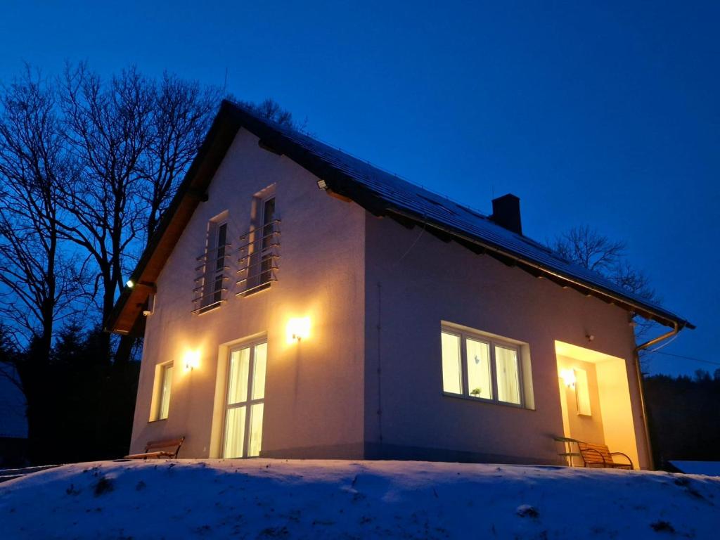 a house lit up in the snow at night at Dom w Miłkowie k Karpacza z widokiem na Karkonosze in Miłków
