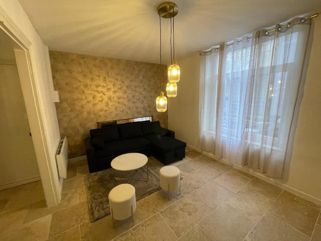 un salon avec un canapé noir et une table dans l'établissement Le Havre de Charme, à Boulogne-sur-Mer