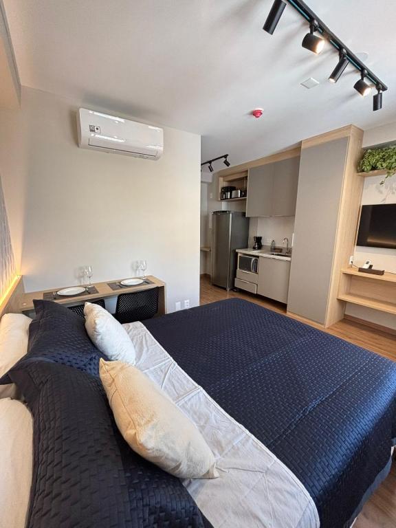 Hotel Studio novo e equipado próximo ao metrô e Consulado Americano, a bedroom with a large bed and a kitchen at Studio novo e equipado próximo ao metrô e Consulado Americano in São Paulo