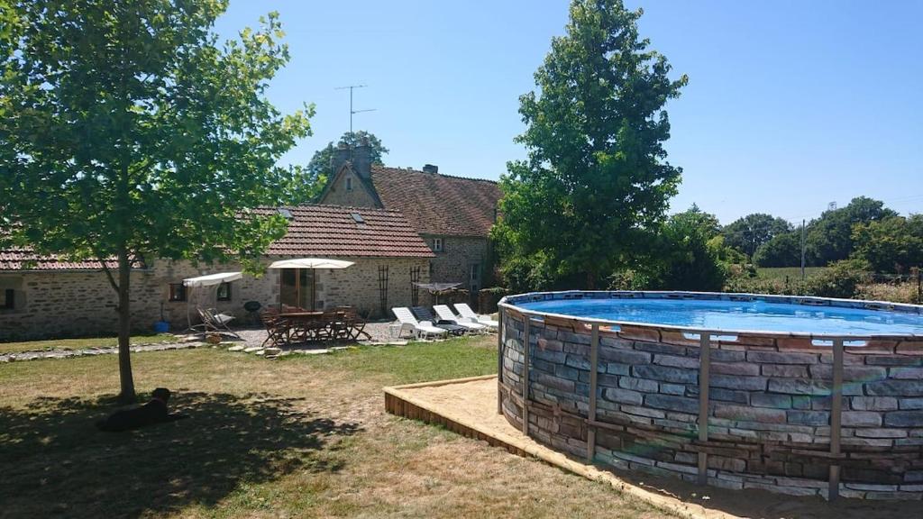 - une grande piscine dans la cour d'une maison dans l'établissement Gite de la foret, à Saint-Plantaire