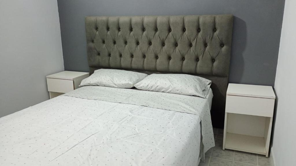 ein Schlafzimmer mit einem großen Bett und zwei Nachttischen in der Unterkunft Dpto en San Antonio Oeste 2 pax in San Antonio Oeste