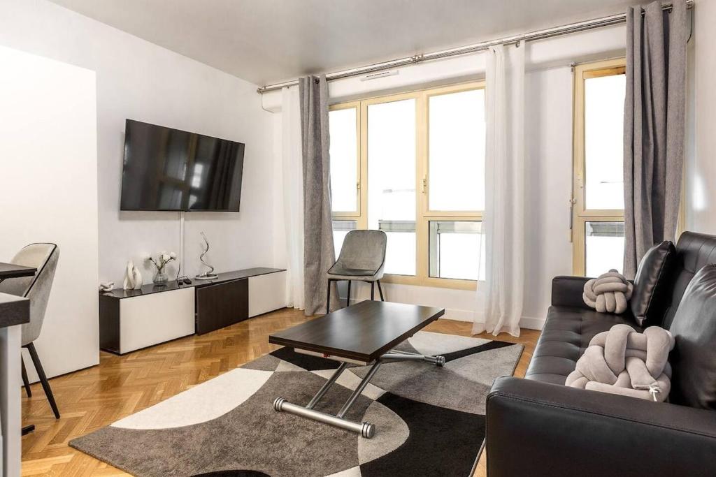 un salon avec un canapé et une table dans l'établissement Stylish Escape in the Vibrant 11th arrondissement, à Paris