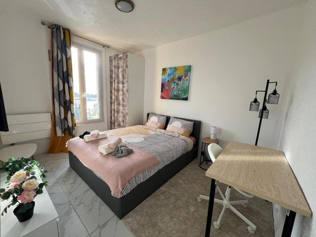 a small bedroom with a bed and a table at Grand T1 confortable - Calme et Proche de Paris in Montreuil