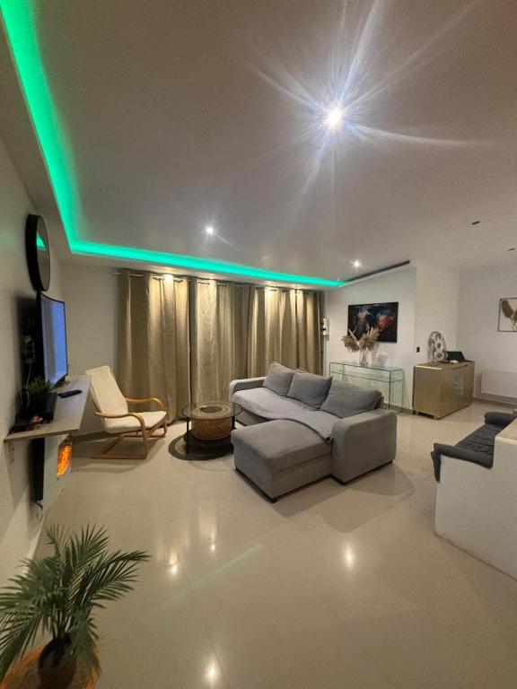 ヴィルモンブルにあるJacuzzi House - 1-Bed & Parking - Villemomble, Parisのソファとテレビのあるリビングルーム