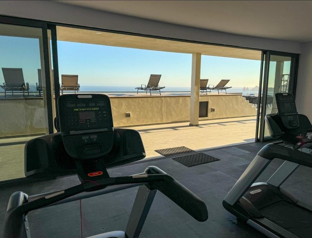 einem Fitnessraum mit Meerblick von einem Gebäude aus in der Unterkunft Departamento de lujo in Cabo San Lucas