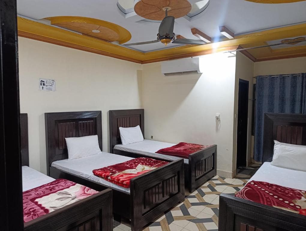 ムルターンにあるHotels Inn Multan Laxen Inn Multan Hotels Pakistanの天井の客室のベッド3台