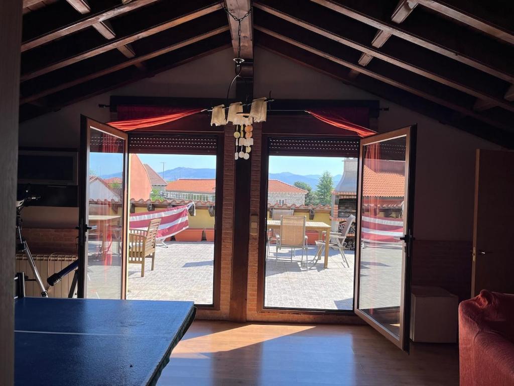 LozoyuelaにあるCasa de la ermitaのパティオを望むガラスのスライドドアが備わる客室です。