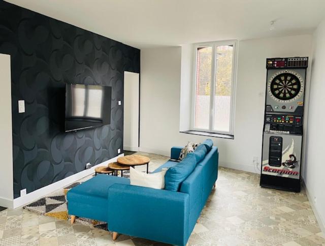 un salon avec un canapé bleu et un réveil dans l'établissement Petite maison au cœur de la ville, à Pouzauges