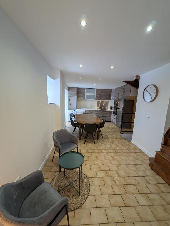 a living room with a table and chairs and a kitchen at Maisonnette in Villar-Saint-Pancrace