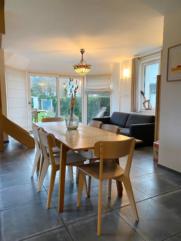 une salle à manger avec une table et des chaises en bois dans l'établissement Les Bulots - Charmante villa wissantaise, à Wissant
