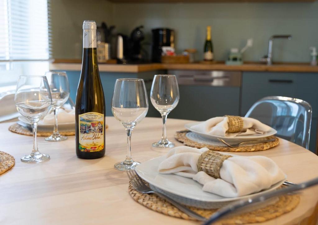 - une table avec une bouteille de vin et deux verres dans l'établissement L'Orée des Thermes, à Niederbronn-les-Bains