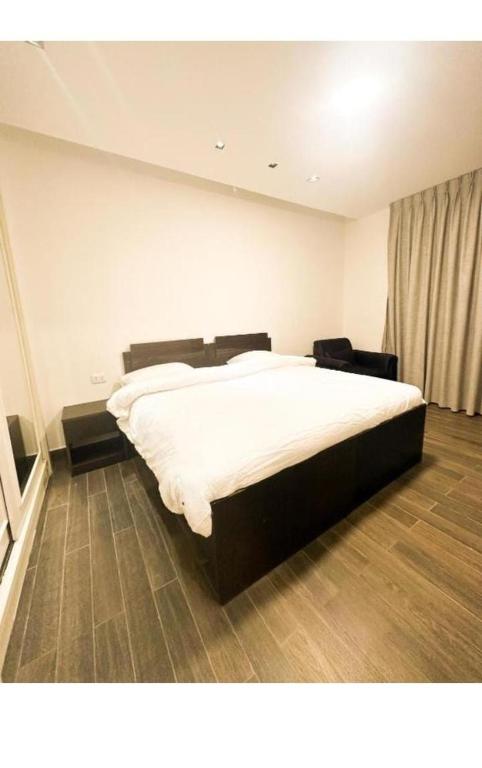 una camera da letto con un letto grande con lenzuola bianche di الجوهره ad Amman