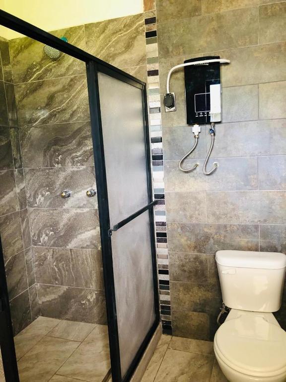 uma casa de banho com um chuveiro e um WC. em Rincon Arrayán em Otavalo