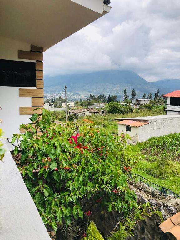 uma vista da varanda de uma casa com flores em Rincon Arrayán em Otavalo