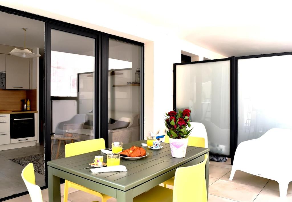 une salle à manger avec une table et des chaises jaunes dans l'établissement Apt confortable avec terrasse et parking, à Sète