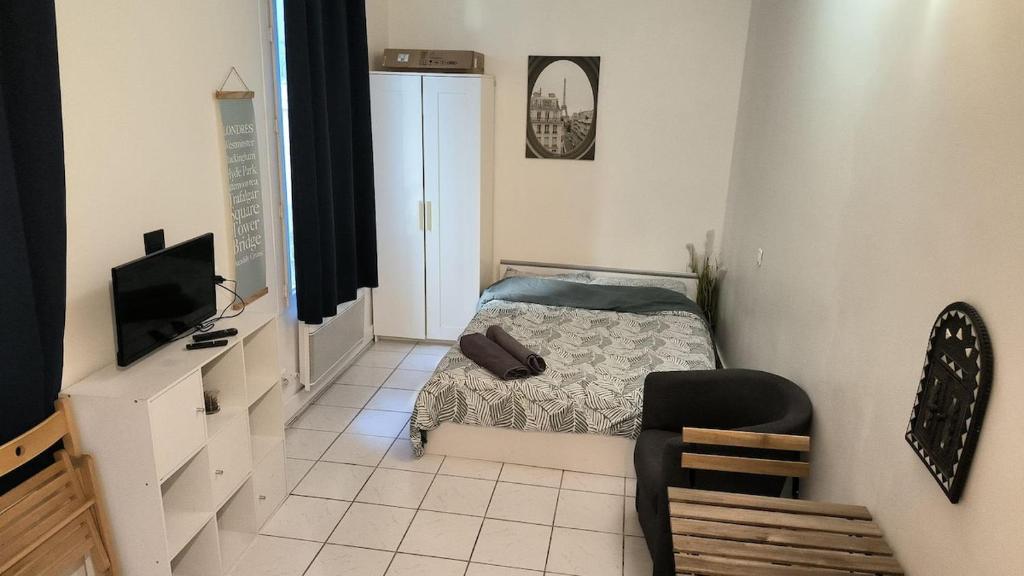 une petite chambre avec un lit et une chaise dans l'établissement Entire Studio - Arena La Chapelle, à Paris