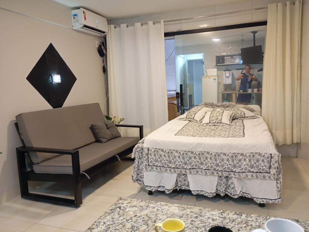 a bedroom with a bed and a chair and a mirror at A 5 km do aeroporto no centro do Nucleo Bandeirante 156 in Brasilia