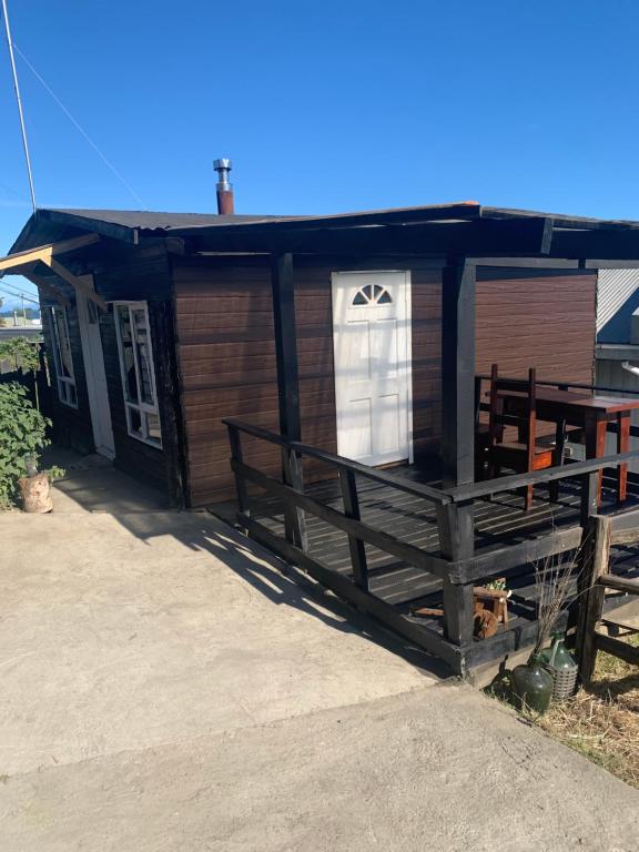 a small house with a white window and a porch at Casa de Mar in Quellón