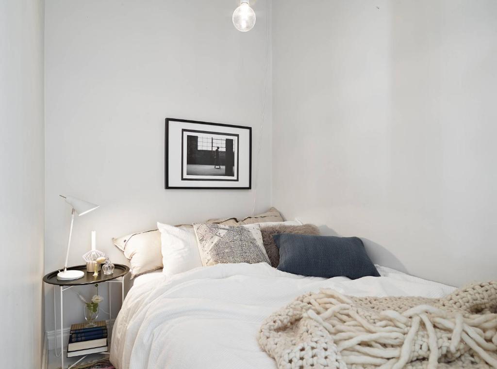 - une chambre avec un lit blanc et une couverture dans l'établissement Cozy appart next Paris and aéroport CDG, à Sevran