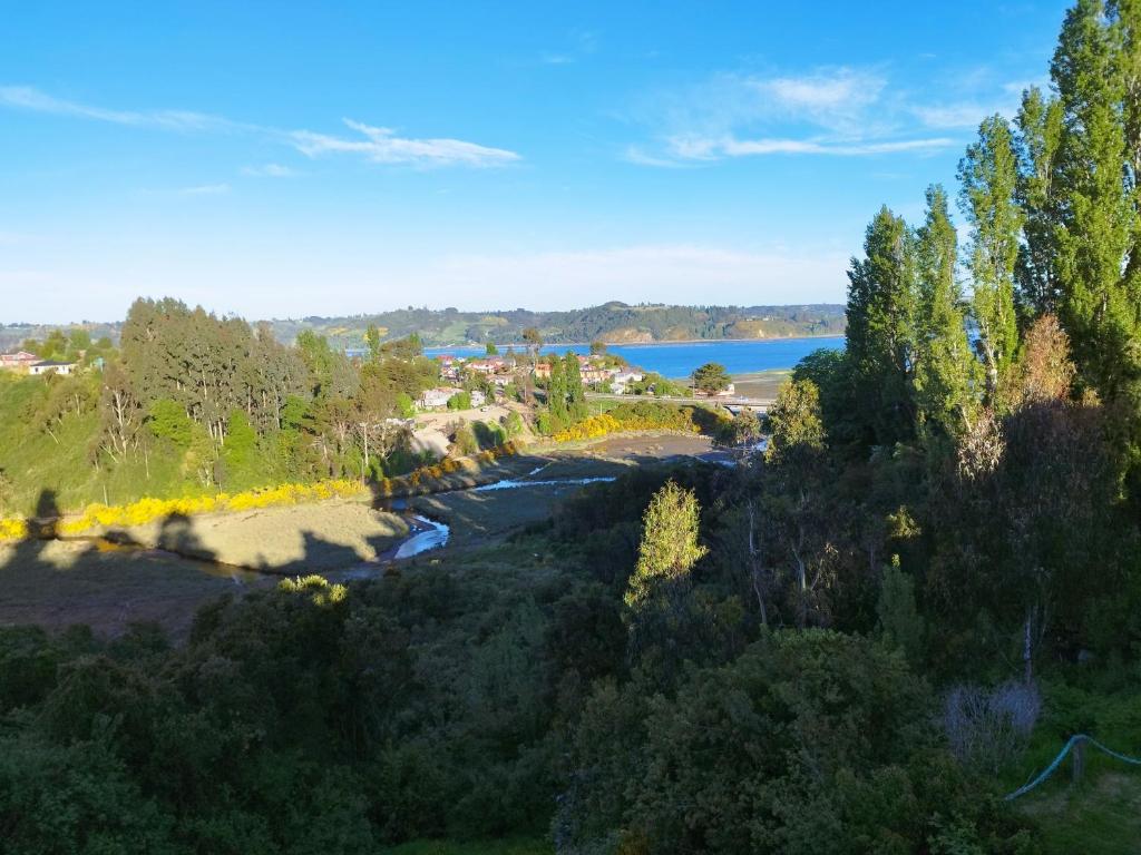 una vista aerea su un fiume e sugli alberi di Cabañas y hostal Aurora a Castro