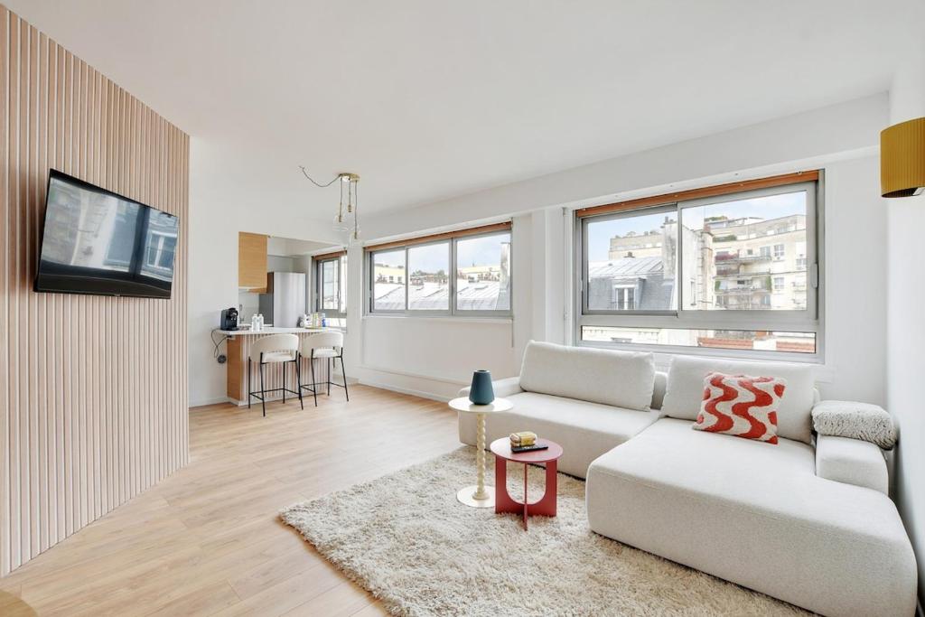 un salon blanc avec un canapé et une table dans l'établissement Eiffel Tower - Passy, Paris, à Paris