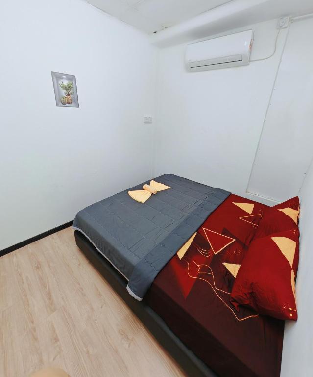 a bed in a white room with a comforter at Fywen Motels in Changlun