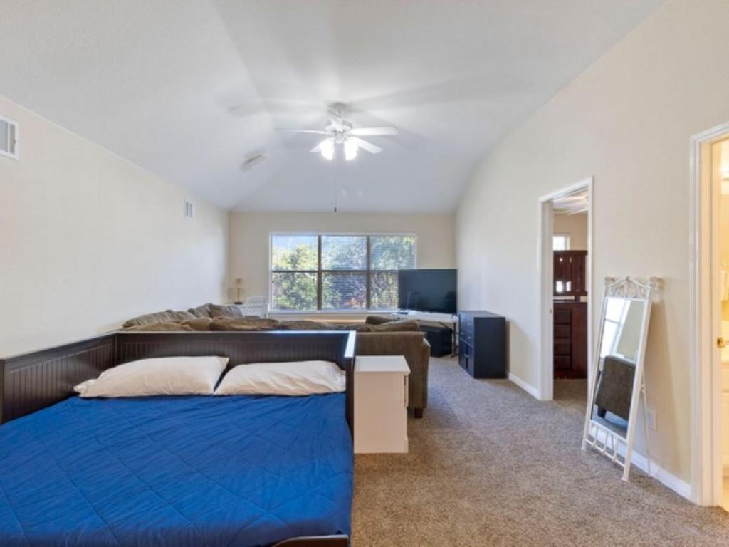 ein Schlafzimmer mit einem blauen Bett und einem Sofa in der Unterkunft Cozy Sunterro Serenity in North Austin Pet Friendly in Austin