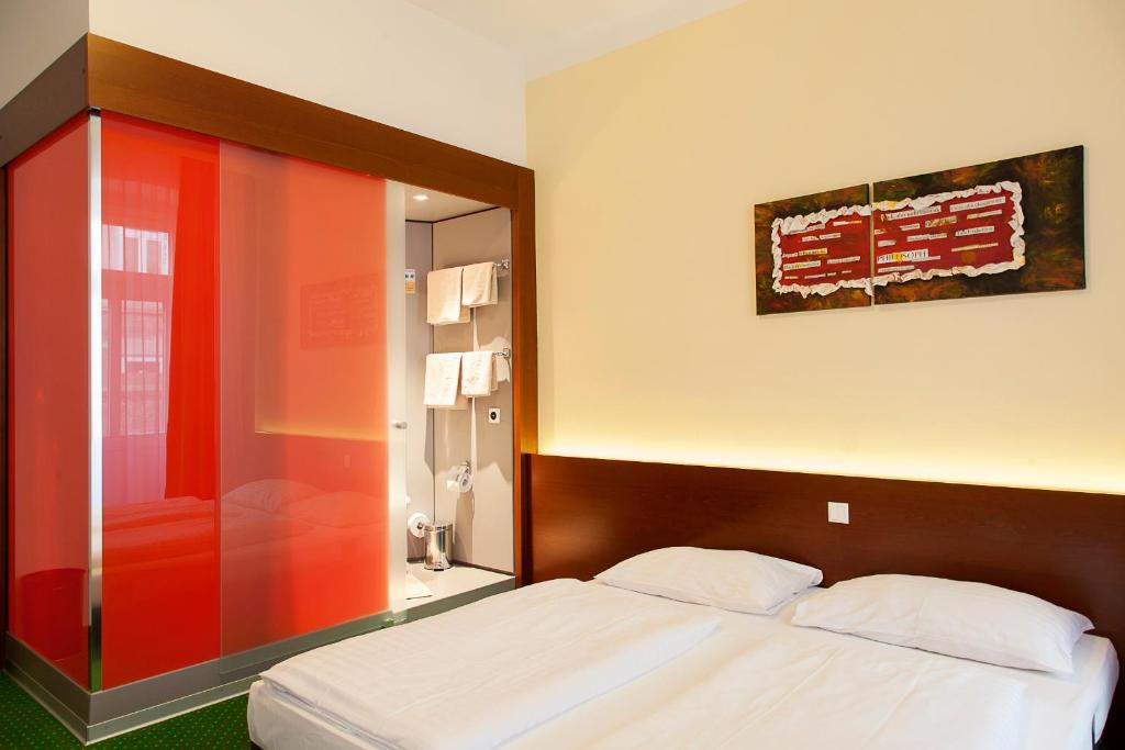 sypialnia z dużym łóżkiem i czerwoną szafką w obiekcie Pension Stadthalle w Wiedniu