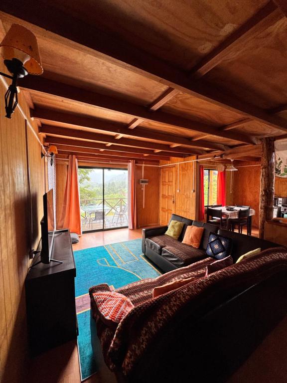 una sala de estar con un sofá y una mesa en Casa con vista a Futaleufú, en Futaleufú
