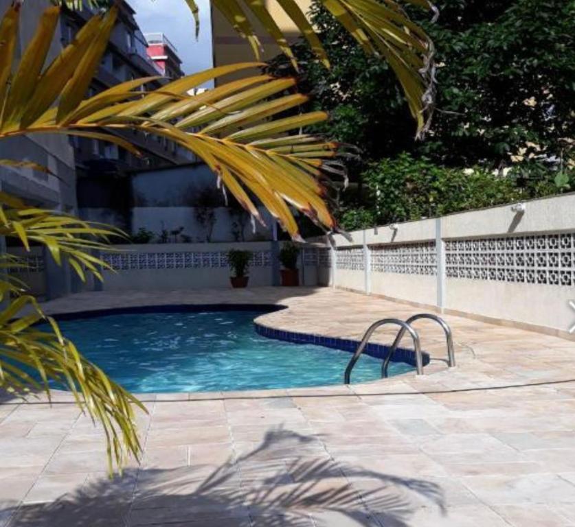 a swimming pool in a yard with a fence at Apartamento enseada in Guarujá
