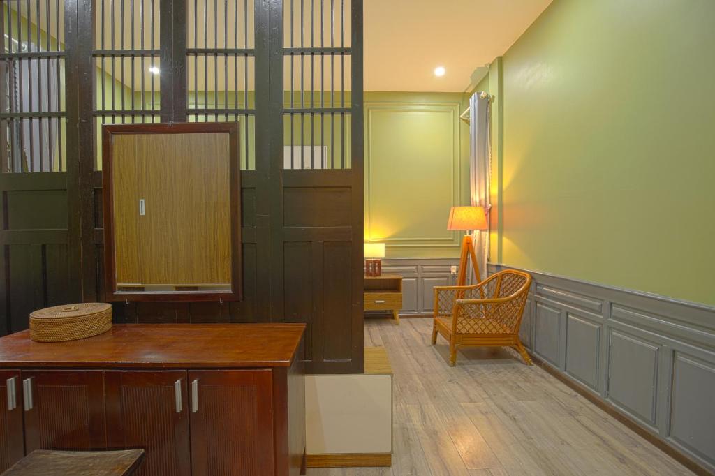A compact sitting and work area with a wooden desk, cabinet, and wicker chair.