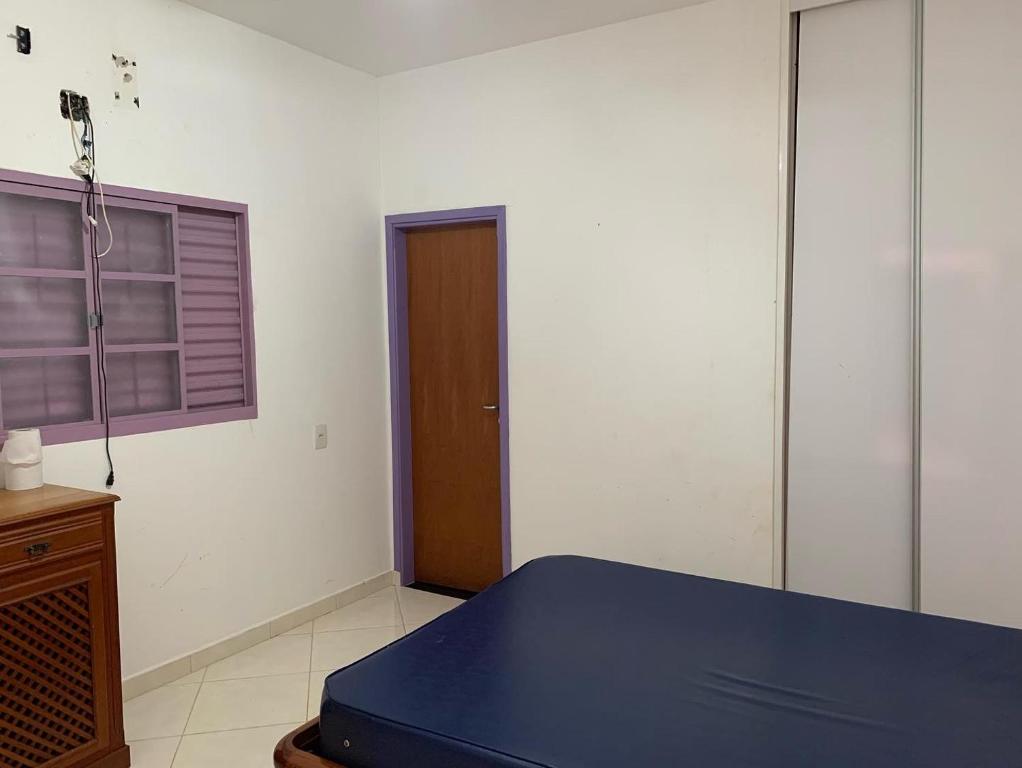a room with a blue bed and a window at Chácara da Acácias in Sao Jose do Rio Preto