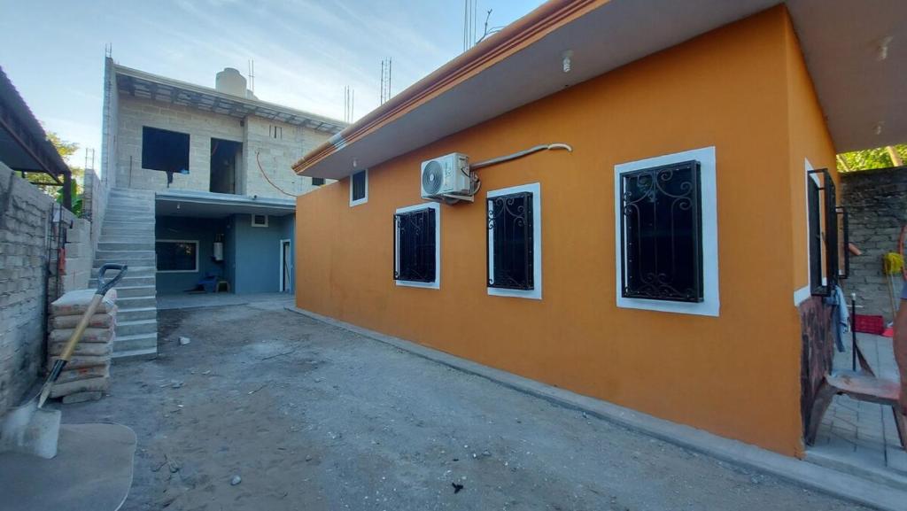 eine orangefarbene Wand eines Gebäudes mit Fenstern und einem Gebäude in der Unterkunft Comfortable apartment in San Blas in San-Blas-Inseln