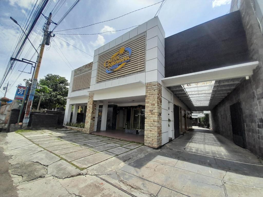 a building with a sign on the side of it at Cahya Nirwana Hotel Purwokerto in Purwokerto