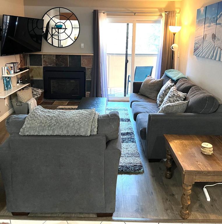 a living room with a couch and a fireplace at Renovated condo steps from Beaver Creek shuttle in Avon